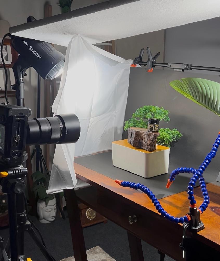 Behind the scenes at a StudioPro partner studio — hands adjusting camera gear beside a monitor and notebook.
